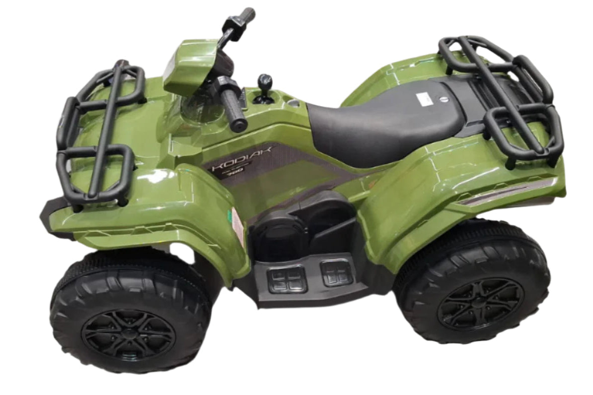 Green toy ATV on a tiled floor with a box in the background